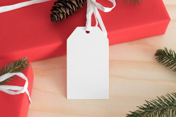 Wall Mural - White blank tag mockup isolated on a red christmas gift.