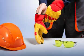 Builder putting protection gloves on hands. Safety construction.