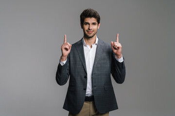 Poster - Photo of cheerful businessman smiling and pointing fingers upward