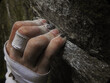 © Yojak Vasa - Rock climbers fingers holding on to a crimp on rock, while bouldering, with chalk and tape on hand. Hanging on to the edge of a rock, close-up.