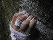 Rock climbers fingers holding on to a crimp on rock, with chalk and tape on hand. High Resolution 