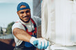 © fotofabrika - Young black man repairman checking an outside air conditioner unit