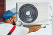 © fotofabrika - Repairman in uniform installing the outside unit of air conditioner