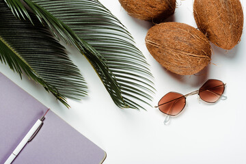 Poster - top view of green palm leaves, sunglasses, coconuts and notepad on white background