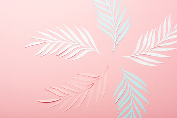 Wall Mural - top view of white, pink and blue paper cut palm leaves on pink background