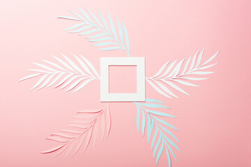 Wall Mural - top view of white, pink and blue paper cut palm leaves and square frame on pink background