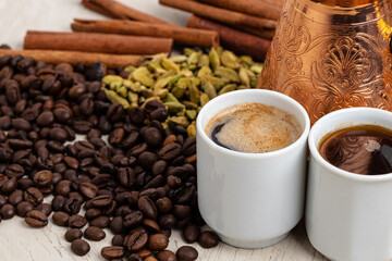 Cup of coffee with roasted beans, seeds and cinnamon