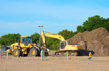 excavator and bulldozer at a construction site with a large pile of dirt preparing for home or comme