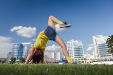 Brunette Girl Dancing, Jumping, Doing Acrobatics And Posing, In A City Park Near The Lake On A Sunny Day