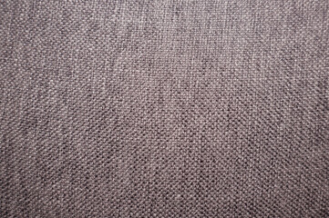 close view of a grey rustic fabric texture. to use as background. Taken indoors under a bright white light