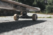 Closeup Of A Skateboard On The Ground Under The Sunlight With A Blurry Background