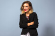 ©  AnnaHar - Young stylish business woman posing at grey background, wearing black jacket and bright make up.