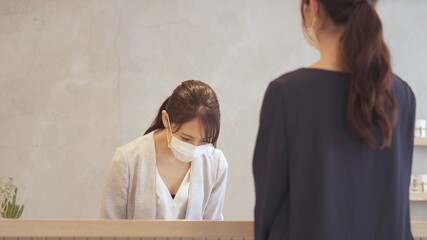 マスクを着用して接客をする女性