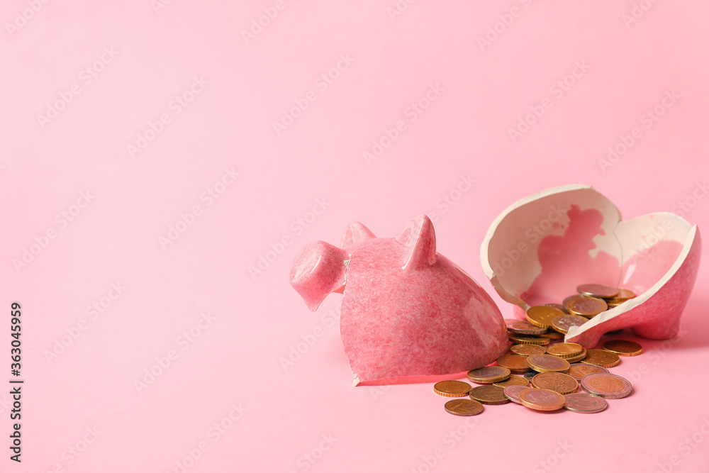 Broken piggy bank and coins on color background