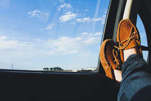 Low Section Of Woman Wearing Shoes In Car Against Blue Sky