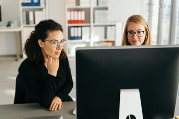 Poster - Two young woman working on a business team