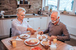 © bnenin - Beautiful senior couple eating breakfast.