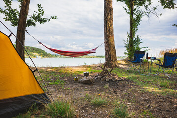view of camping near lake with hammock between trees