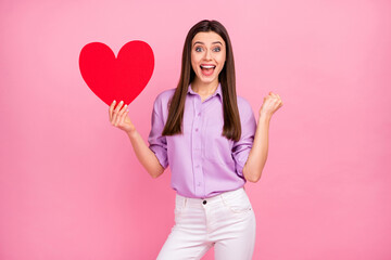 Wall Mural - Portrait of her she nice attractive lovely pretty lovable cute cheerful cheery long-haired girl holding in hand big large paper heart having fun isolated on pink pastel color background