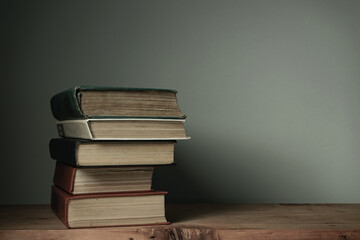 Poster - Beautiful open books on a old red wooden table and white wall background.