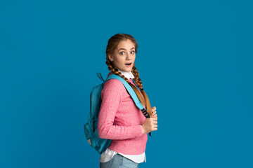 Wall Mural - Teenage girl with backpack on blue background