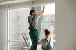 © New Africa - Professional workers tinting window with foil indoors