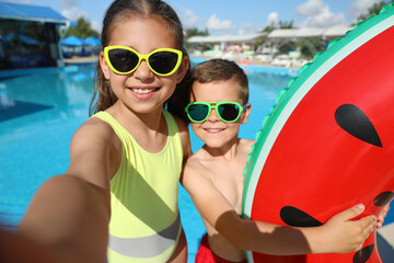 Happy children taking selfie near swimming pool. Summer vacation