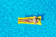 © New Africa - Young woman with inflatable mattress in swimming pool, top view