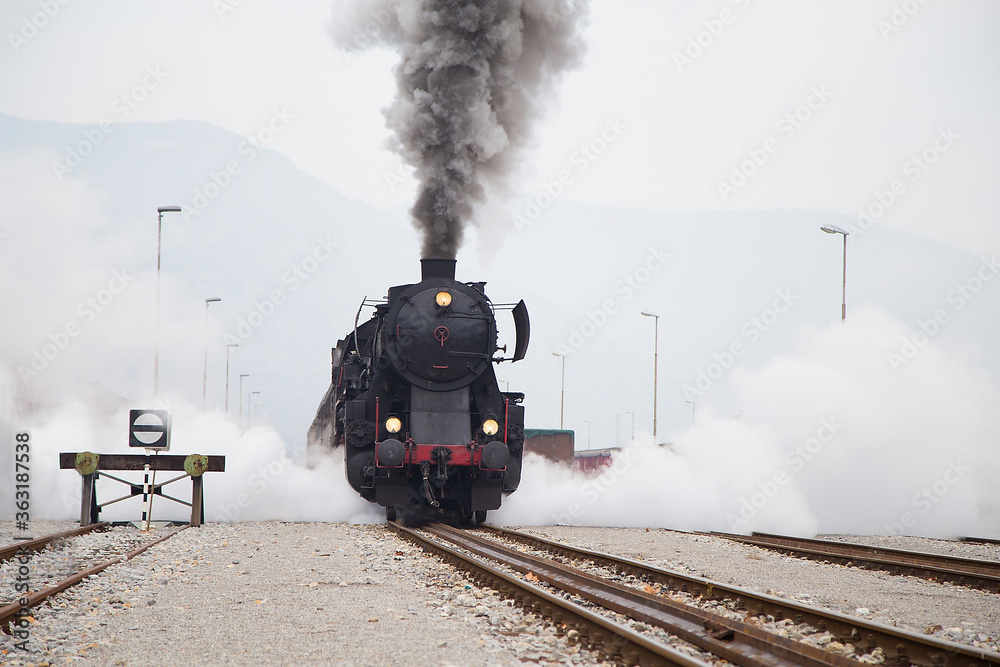 Old Steam train - locomotive is leaving the Railway Station at Nova Gorica, Slovenia - obrazy, fototapety, plakaty 