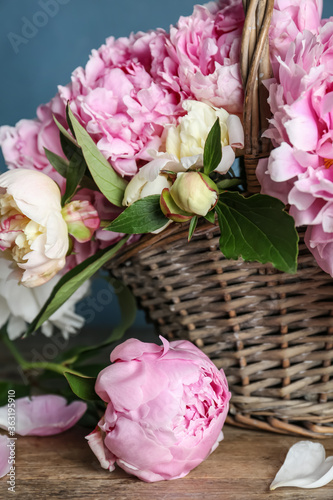 Photographie Beautiful peonies in wicker basket on wooden table