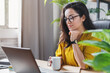 © InsideCreativeHouse - Young woman enjoying her coffee while working or studying on laptop computer at home office