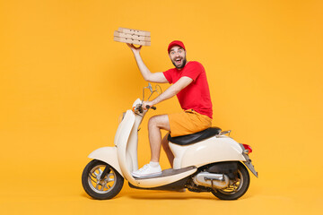 Wall Mural - Delivery man in red cap t-shirt uniform driving moped motorbike scooter hold pizza in cardboard flatbox isolated on yellow background studio Fun guy employee working courier Service quarantine concept