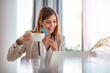 © Dragana Gordic - Online doctor with a protective mask tutoring over the internet. Drinking morning coffee. Businesswoman wearing face mask while working on a computer and drinking coffee in the office.