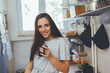 © cherryandbees - woman drinking morning coffee or tea in her kitchen