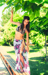 Wall Mural - girl with long hair in a swimsuit walking on the tropics