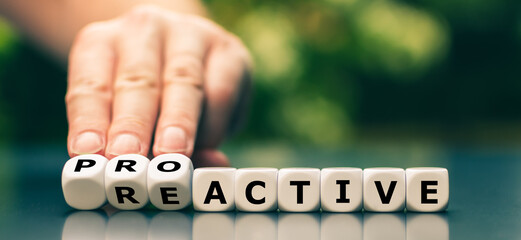 Wall Mural - Hand turns dice and changes the word reactive to proactive.