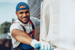 © fotofabrika - Young black man repairman checking an outside air conditioner unit