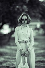 Portrait Of Young Woman Wearing Sunglasses Standing In Park