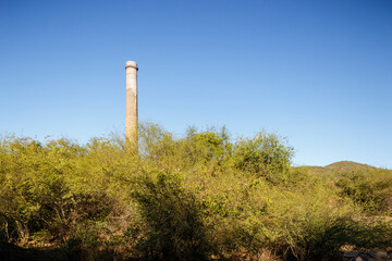 Horizontal wide view of restored Smokestack «La Ramona» built in 1890 in industrial mining ruin in El Triunfo, Baja California Sur, Mexico