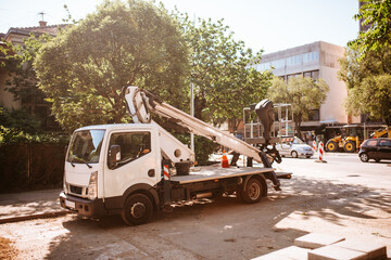 White van - road crane in front of the construction site. 