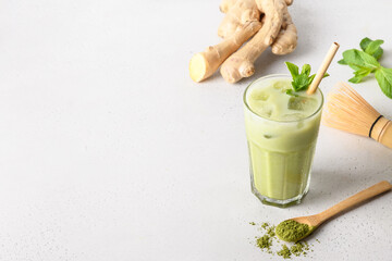 Wall Mural - Iced Green matcha tea with ginger on white table. View from above.