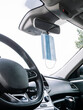 © karrastock - Protective face mask hanging from a car's rear view mirror.