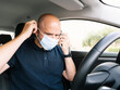 © karrastock - Man protects himself with mask inside the car
