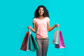 Wall Mural - Happy smiling female fashion blogger holding bunches of paper shopping bags