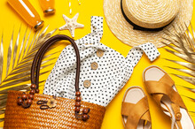 Summer Background Beach Accessories. Beach Wicker Straw Rattan Women's Eco Bag White Dress Hat Golden Tropical Leaf Juice In Glass Jars Straws Shells Starfish On Yellow Background. Flat Lay Top View
