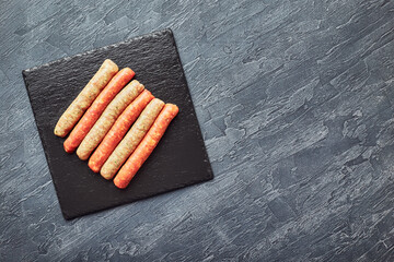 Wall Mural - Raw butchers sausages on slate. Overhead view