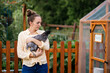 © MeganBetteridge - Woman holding wyandotte chicken in her backyard