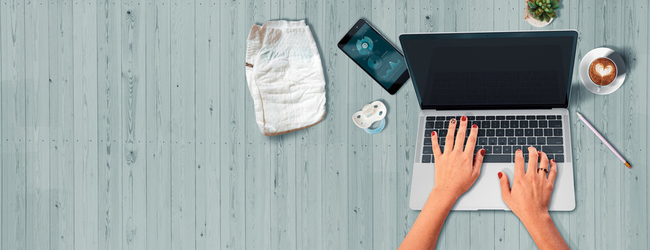 Teletrabajo. Escritorio y manos de mujer en teclado de computador portátil. Trabajo desde casa por el coronavirus