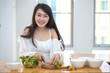 © Morakot - Beautiful Asian women, beautiful smile, good health, beautiful teeth, eating salad vegetable when working at home.