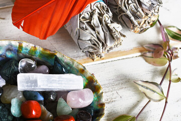 Wall Mural - An image of several tumbled healing crystals in an abalone shell with white sage bundles and sacred feather. 